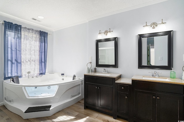 2981 Victor Rd, Longs, SC 29568 - bathroom featuring wood finished floors, double vanity, a textured ceiling, a jetted tub, and ornamental molding