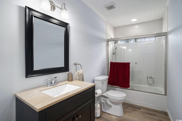 2981 Victor Rd, Longs, SC 29568 - bathroom with toilet, vanity, wood finished floors, enclosed tub / shower combo, and a textured ceiling