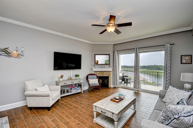 8121 Amalfi Pl Unit 7-805, Myrtle Beach, SC 29572 - living room with a ceiling fan, baseboards, ornamental molding, a tiled fireplace, and wood finished floors