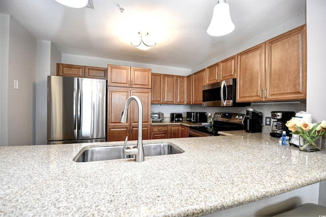8121 Amalfi Pl Unit 7-805, Myrtle Beach, SC 29572 - kitchen featuring stainless steel appliances, a sink, brown cabinetry, and a peninsula