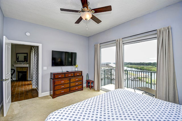 8121 Amalfi Pl Unit 7-805, Myrtle Beach, SC 29572 - carpeted bedroom with access to outside, baseboards, a fireplace, a ceiling fan, and a textured ceiling