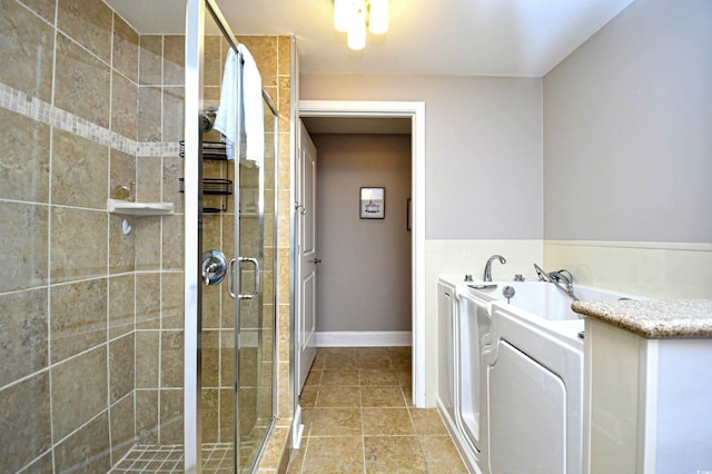 8121 Amalfi Pl Unit 7-805, Myrtle Beach, SC 29572 - full bathroom featuring a shower stall, a garden tub, washer / dryer, tile patterned flooring, and baseboards