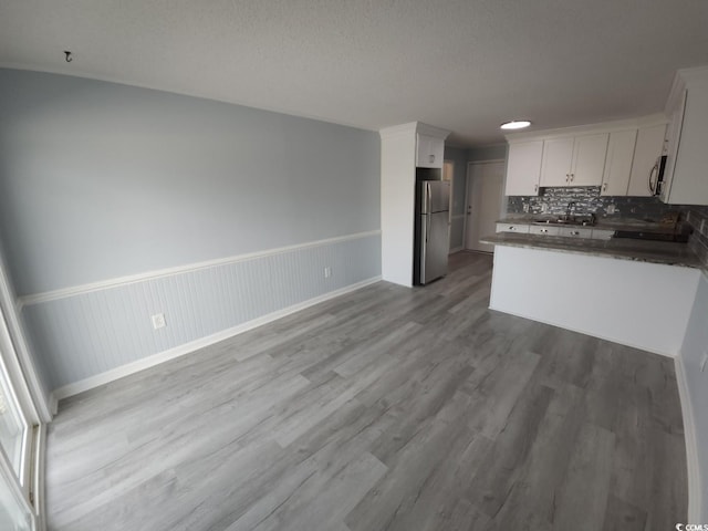 300 47th Ave S Unit 1F, North Myrtle Beach, SC 29582 - kitchen with appliances with stainless steel finishes, dark countertops, wood finished floors, white cabinets, and tasteful backsplash