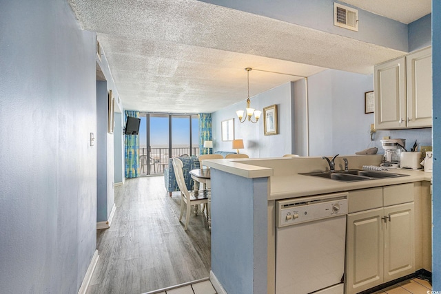 9400 Shore Dr Unit 124, Myrtle Beach, SC 29572 - kitchen featuring white dishwasher, a sink, a peninsula, floor to ceiling windows, and a textured ceiling