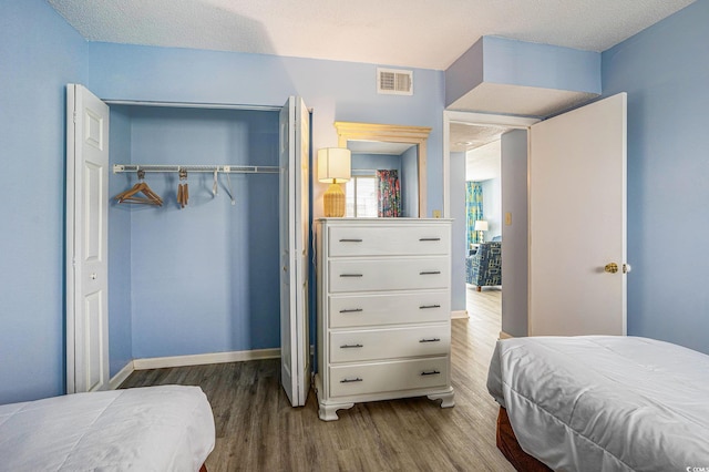 9400 Shore Dr Unit 124, Myrtle Beach, SC 29572 - bedroom with a closet, wood finished floors, a textured ceiling, and baseboards