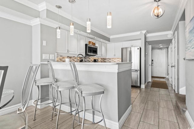 2500 N Ocean Blvd Ph 1, Myrtle Beach, SC 29577 - kitchen featuring stainless steel appliances, a peninsula, white cabinetry, backsplash, and light countertops