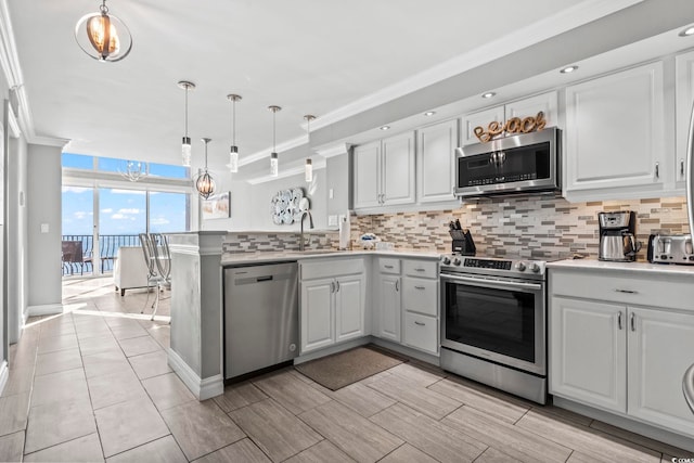 2500 N Ocean Blvd Ph 1, Myrtle Beach, SC 29577 - kitchen with stainless steel appliances, backsplash, ornamental molding, a peninsula, and a sink