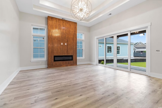 2205 Yellow Morel Way, Myrtle Beach, SC 29579 - unfurnished living room featuring a chandelier, a tray ceiling, light wood-style floors, a fireplace, and baseboards