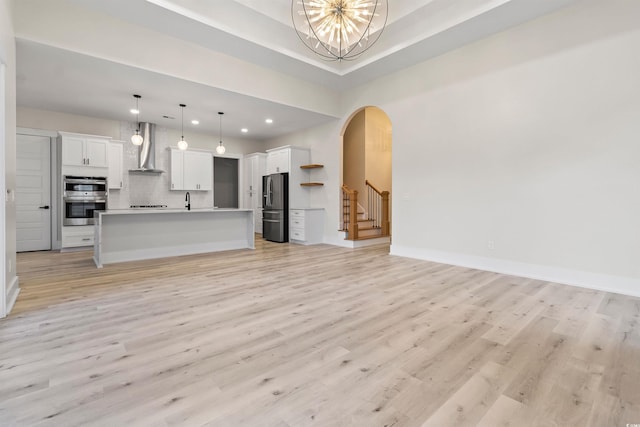2205 Yellow Morel Way, Myrtle Beach, SC 29579 - unfurnished living room with arched walkways, a chandelier, light wood-style floors, recessed lighting, and a sink
