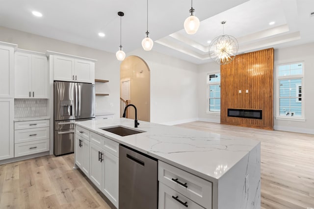 2205 Yellow Morel Way, Myrtle Beach, SC 29579 - kitchen with stainless steel appliances, a sink, light wood finished floors, arched walkways, and a kitchen island with sink