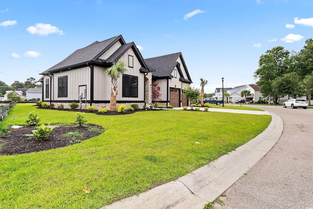 2205 Yellow Morel Way, Myrtle Beach, SC 29579 - view of front of house featuring concrete driveway, an attached garage, board and batten siding, a front lawn, and roof with shingles