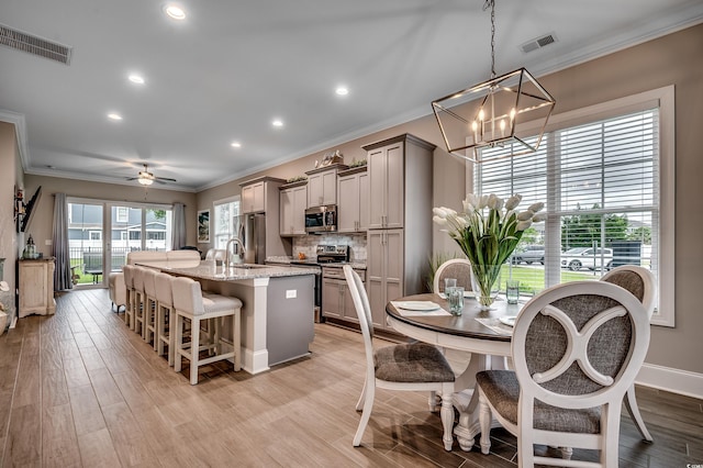 620 Lorenzo Dr Unit 620, North Myrtle Beach, SC 29582 - kitchen featuring appliances with stainless steel finishes, ornamental molding, a chandelier, a breakfast bar area, and gray cabinetry