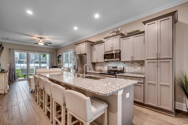 620 Lorenzo Dr Unit 620, North Myrtle Beach, SC 29582 - kitchen with appliances with stainless steel finishes, a sink, a kitchen bar, a kitchen island with sink, and light wood-style flooring