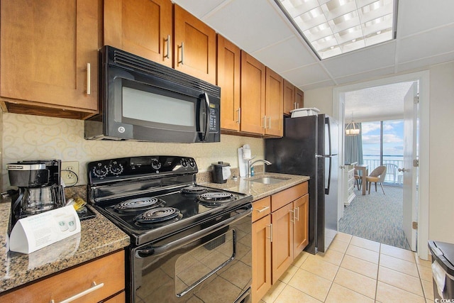 1105 S Ocean Blvd Unit 520, Myrtle Beach, SC 29577 - kitchen featuring black appliances, a sink, brown cabinets, and stone countertops