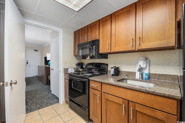 1105 S Ocean Blvd Unit 520, Myrtle Beach, SC 29577 - kitchen with black appliances, a sink, brown cabinets, light tile patterned floors, and dark stone countertops