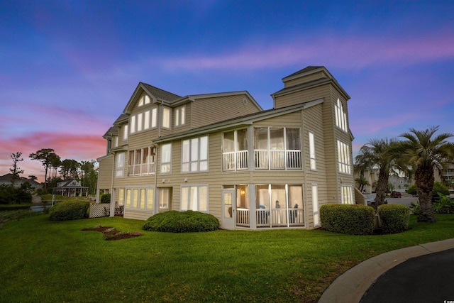 222 Landing Rd Unit 1811, North Myrtle Beach, SC 29582 - back of house at dusk with a lawn and a sunroom