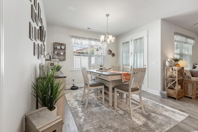 462 Pacific Commons Dr, Surfside Beach, SC 29575 - dining area with healthy amount of natural light, a chandelier, wood finished floors, and baseboards