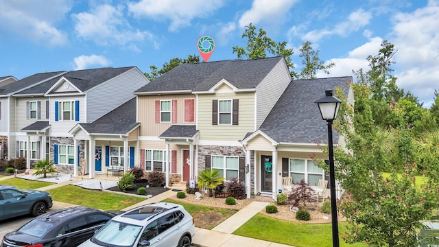 837 Triple Ct Unit 837, Myrtle Beach, SC 29588 - townhome / multi-family property with stone siding, uncovered parking, a front lawn, and roof with shingles