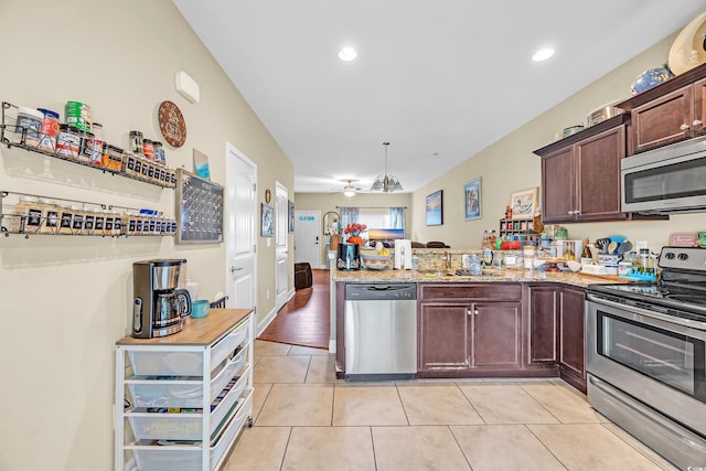 837 Triple Ct Unit 837, Myrtle Beach, SC 29588 - kitchen with stainless steel appliances, a peninsula, a ceiling fan, light tile patterned floors, and dark brown cabinets