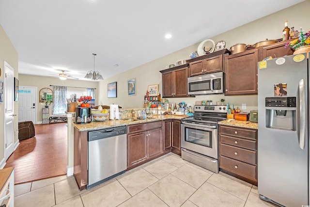 837 Triple Ct Unit 837, Myrtle Beach, SC 29588 - kitchen featuring stainless steel appliances, a ceiling fan, a peninsula, light tile patterned flooring, and light stone counters