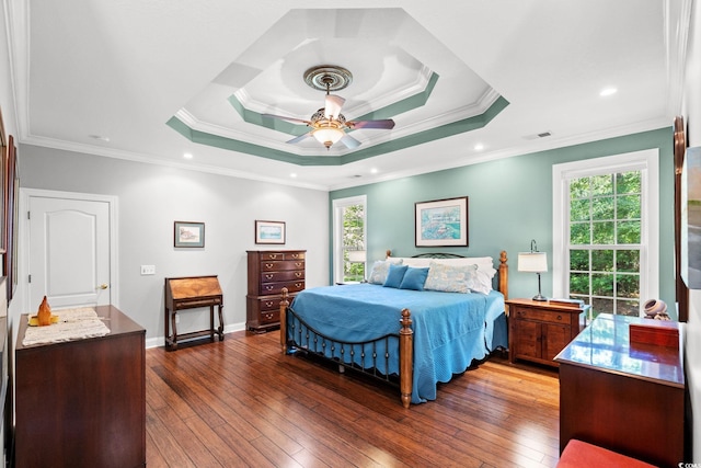 6572 Wellington Dr, Murrells Inlet, SC 29576 - bedroom featuring multiple windows, dark wood-style floors, a tray ceiling, and crown molding