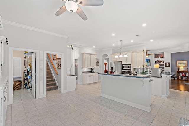 6572 Wellington Dr, Murrells Inlet, SC 29576 - kitchen with stainless steel appliances, arched walkways, a ceiling fan, ornamental molding, and dark countertops