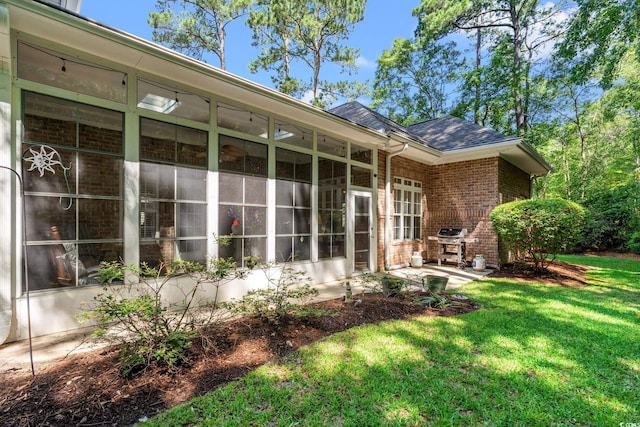 6572 Wellington Dr, Murrells Inlet, SC 29576 - rear view of house with brick siding, a sunroom, a lawn, and a shingled roof