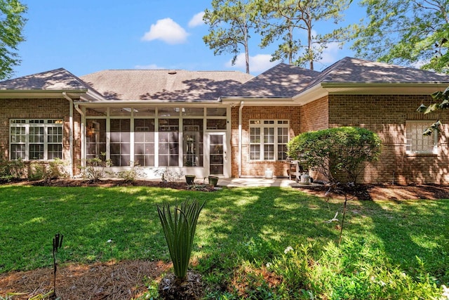 6572 Wellington Dr, Murrells Inlet, SC 29576 - back of property with brick siding, a lawn, a sunroom, and roof with shingles
