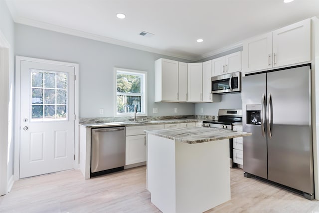 155 Mckenzie Cir, Pawleys Island, SC 29585 - kitchen with appliances with stainless steel finishes, crown molding, light stone countertops, a kitchen island, and recessed lighting