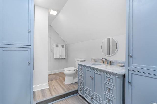 702 Compass Point Dr, North Myrtle Beach, SC 29582 - bathroom featuring wood finished floors, vanity, toilet, vaulted ceiling, and baseboards