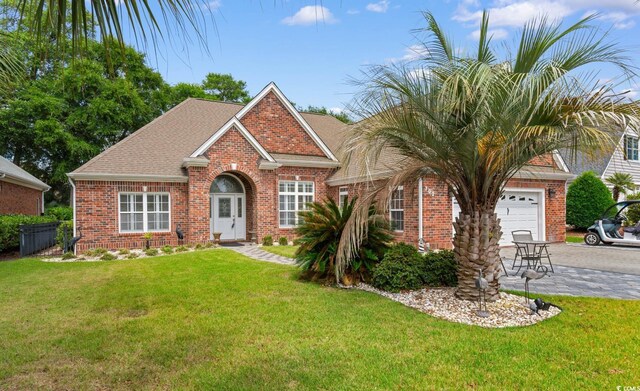 702 Compass Point Dr, North Myrtle Beach, SC 29582 - view of front of house with an attached garage, brick siding, a front yard, and driveway