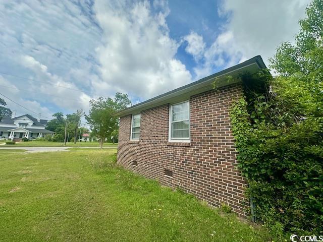 905 E Main St, Dillon, SC 29536 - view of side of property with brick siding and a lawn