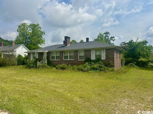 905 E Main St, Dillon, SC 29536 - view of front of house with brick siding, a front lawn, and a chimney