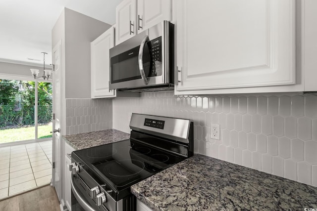 1676 Citadel Ln, Myrtle Beach, SC 29577 - kitchen with stainless steel appliances, white cabinetry, decorative backsplash, and dark stone countertops