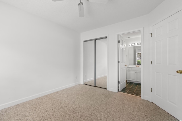 4505 Lightkeepers Way Unit 24B, Little River, SC 29566 - unfurnished bedroom featuring dark colored carpet, ensuite bathroom, a closet, baseboards, and a ceiling fan