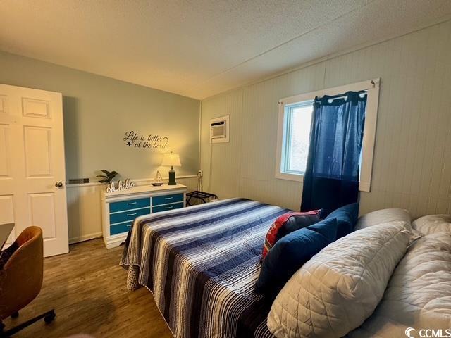 5409 N Ocean Blvd Unit 111, North Myrtle Beach, SC 29582 - bedroom featuring wood finished floors and a wall unit AC