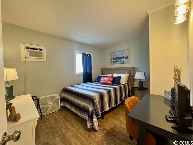 5409 N Ocean Blvd Unit 111, North Myrtle Beach, SC 29582 - bedroom with wood finished floors and a wall mounted air conditioner