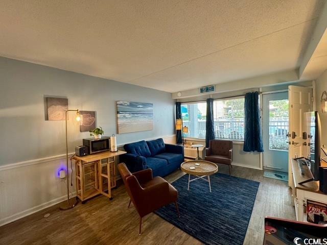 5409 N Ocean Blvd Unit 111, North Myrtle Beach, SC 29582 - living room featuring wood finished floors, baseboards, and a textured ceiling