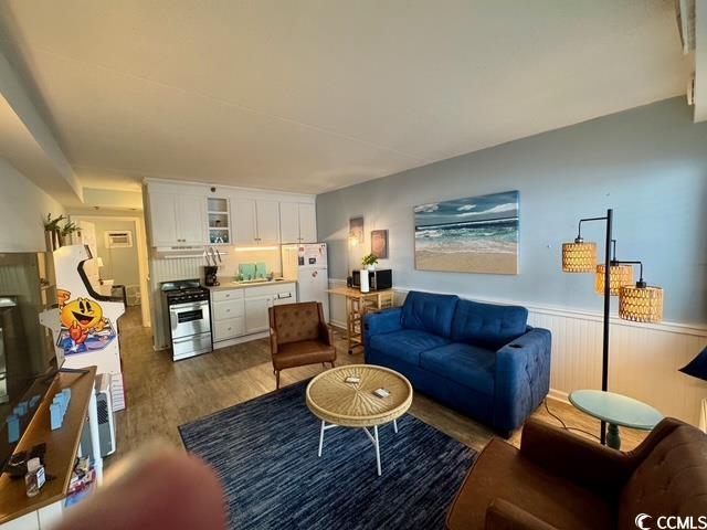 5409 N Ocean Blvd Unit 111, North Myrtle Beach, SC 29582 - living room featuring wood finished floors and wainscoting