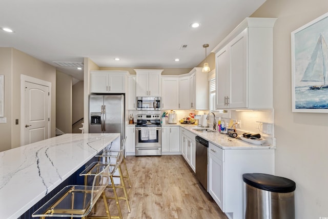 141 Marblehead Dr, Little River, SC 29566 - kitchen featuring appliances with stainless steel finishes, a sink, light wood-style flooring, white cabinetry, and recessed lighting