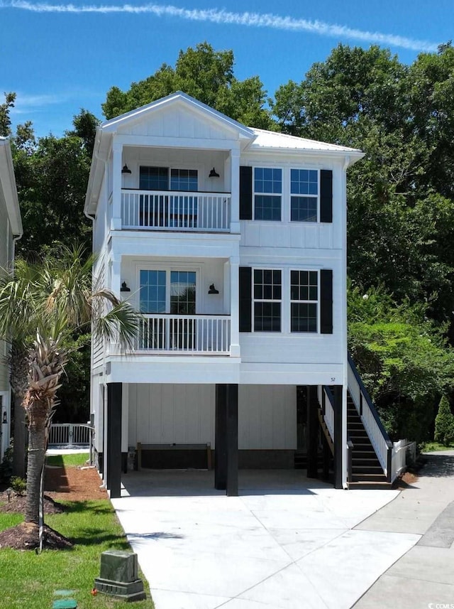 52 Fish Shack Aly, Murrells Inlet, SC 29576 - raised beach house featuring a balcony, a carport, driveway, and stairs