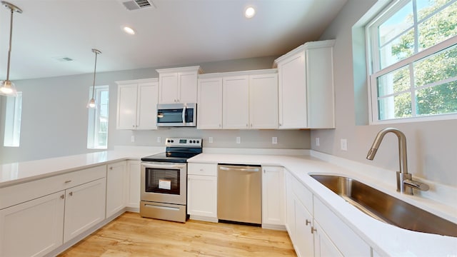 52 Fish Shack Aly, Murrells Inlet, SC 29576 - kitchen with appliances with stainless steel finishes, recessed lighting, white cabinetry, pendant lighting, and light wood finished floors