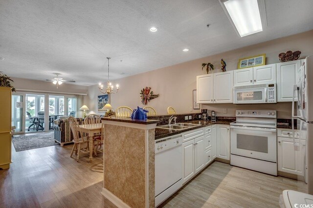 601 Hillside Dr N Unit 3704, North Myrtle Beach, SC 29582 - kitchen with white appliances, a peninsula, light wood-style floors, open floor plan, and a sink