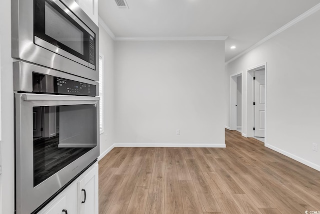 1529 Bucksport Rd, Conway, SC 29527 - kitchen with appliances with stainless steel finishes, ornamental molding, white cabinetry, light wood finished floors, and baseboards