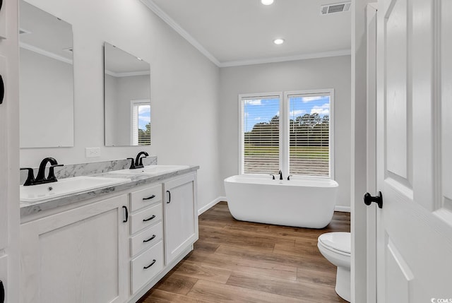 1529 Bucksport Rd, Conway, SC 29527 - bathroom featuring crown molding, double vanity, plenty of natural light, a freestanding tub, and wood finished floors