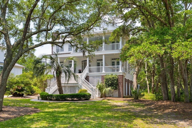 214 Sea Island Dr, Georgetown, SC 29440 - raised beach house featuring stairs, covered porch, a front yard, and brick siding