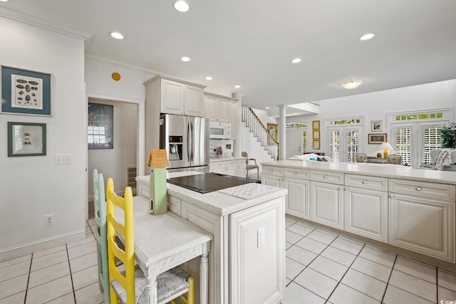 214 Sea Island Dr, Georgetown, SC 29440 - kitchen featuring white microwave, stainless steel fridge, light countertops, light tile patterned floors, and black electric cooktop