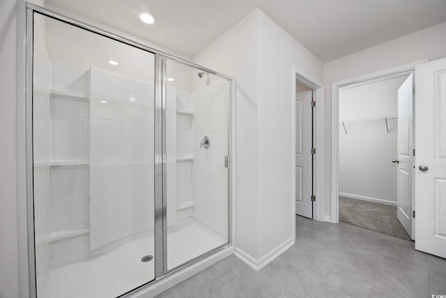 3573 Bells Lake Cir, Longs, SC 29568 - bathroom featuring a shower stall, baseboards, a walk in closet, and tile patterned flooring