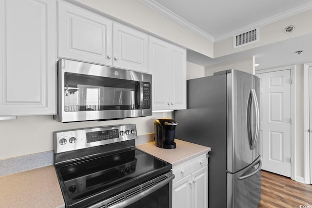 4505 S Ocean Blvd Unit 5D, North Myrtle Beach, SC 29582 - kitchen with appliances with stainless steel finishes, crown molding, white cabinets, light countertops, and wood finished floors