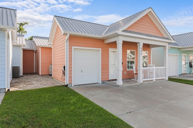 603 Wave Rider Ln Unit 603, North Myrtle Beach, SC 29582 - view of front of home with metal roof, concrete driveway, covered porch, central AC, and a standing seam roof